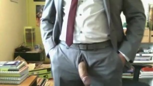 Horny uncut British guy in a grey suit wanks in his office and cums
